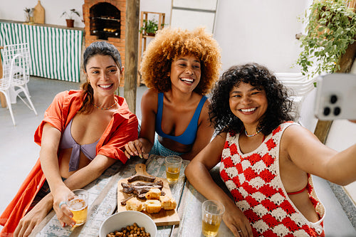 Three friends taking a selfie while enjoying pão de alho and churrasco