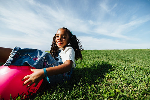 Girl enjoying playful summer moment with bright ball outdoors