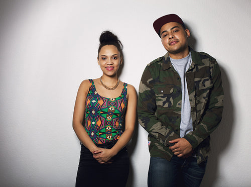 Casual young hipster couple posing together against gray background