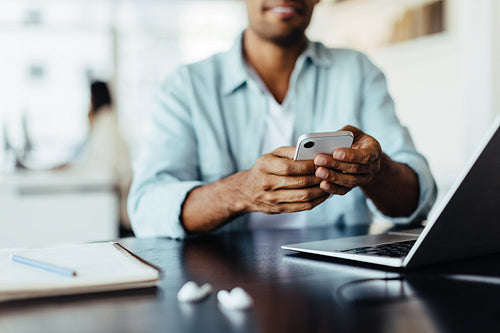 Man sitting in an office and using a mobile phone