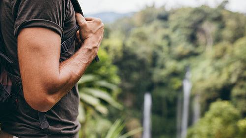 Man hiking near waterfall in forest