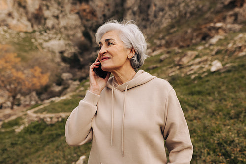 Senior woman taking a phone call outdoors