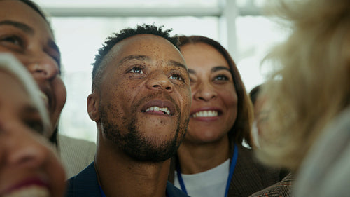Diverse audience at a professional conference attentively engaging and smiling during a presentation
