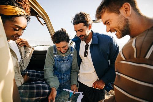 Plotting the next stop: Friends review their map in the sunshine