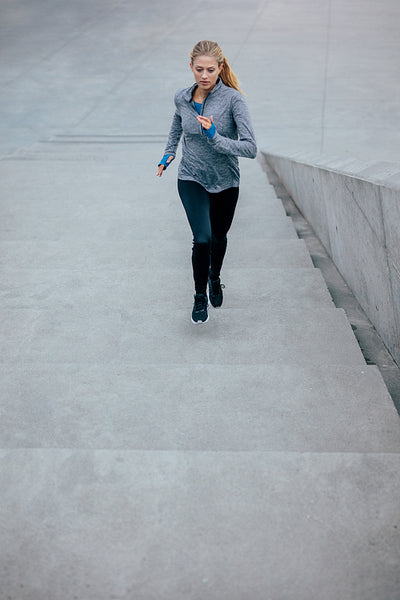 Young sport woman running upstairs