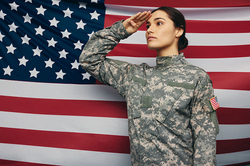 American soldier saluting against the United States flag