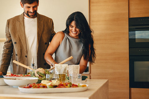 Couple cooking together with fresh ingredients in their modern kitchen