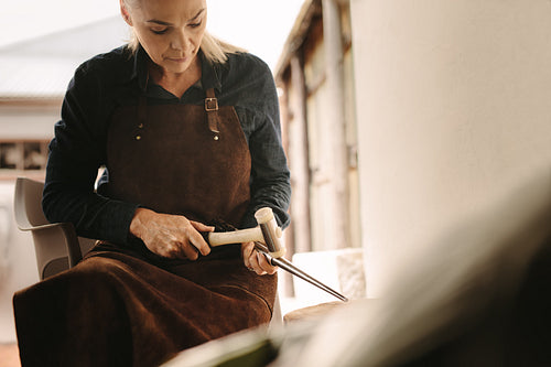 Woman goldsmith making a jewelry at workshop