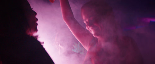 Two girlfriends dancing together at a festival