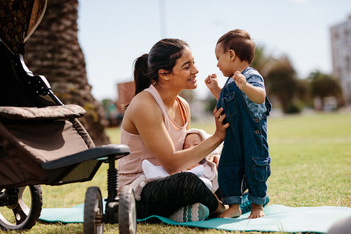 Woman with her two kids sitting in park