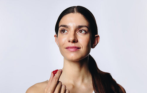 Thoughtful woman in studio taking a gummy