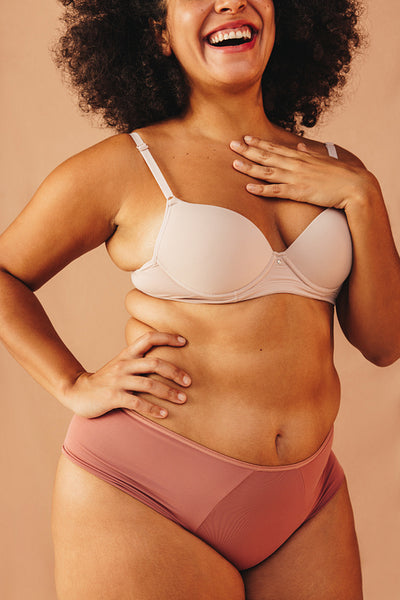 Happy plus size woman embracing her natural body in a studio