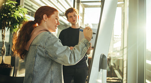 Student writing on board during class