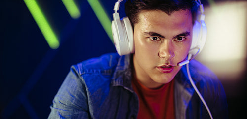 Young male gamer focusing on his pc screen as he plays an online video game