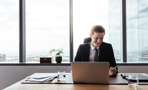 Businessman working at his desk and smiling
