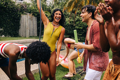 Friends enjoy pool party in sunny backyard