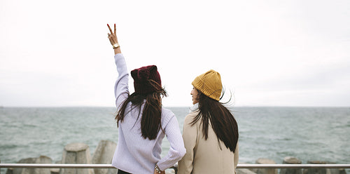 Rear view of two women standing together outdoors