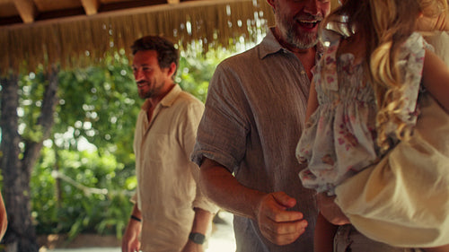 Family arriving to visit grandparents at tropical resort villa