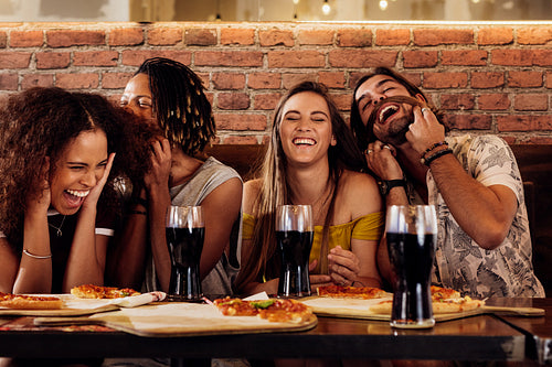 Cheerful young friends hanging out at restaurant