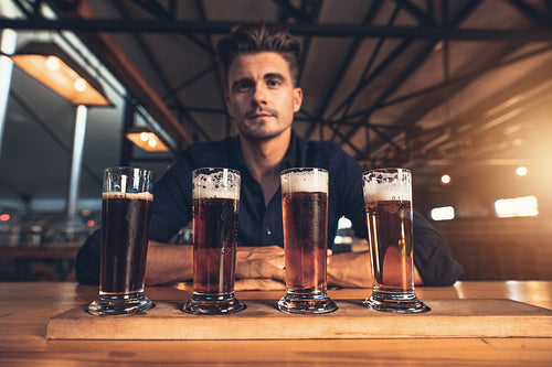 Young man tasting different varieties of craft beer