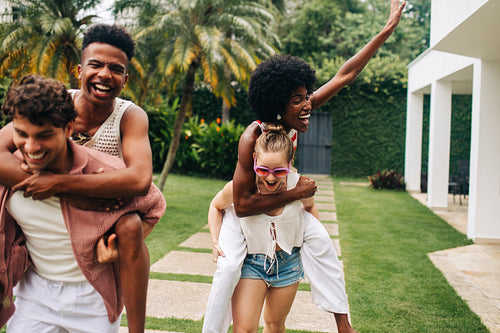 Friends having fun outdoors with piggyback rides
