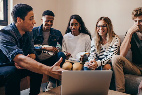 Multi-ethnic group of students with laptop in campus