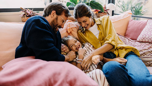 Family laughter on sofa with parents and child