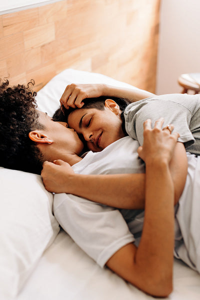 Cute lesbian couple cuddling at home