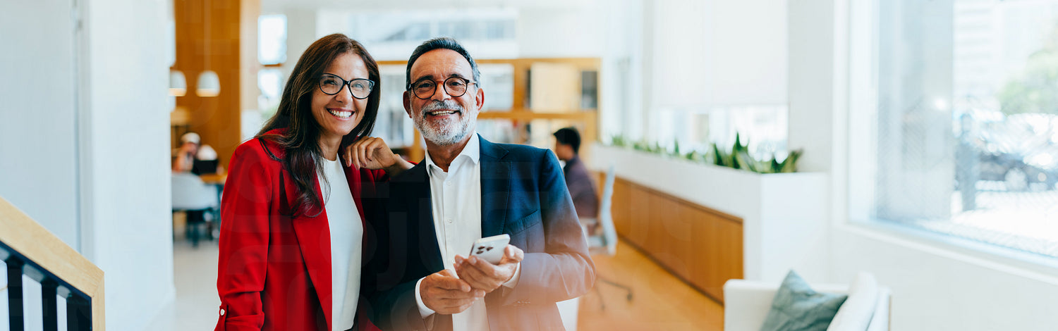 Smiling senior management team posing together in a modern office envi ...