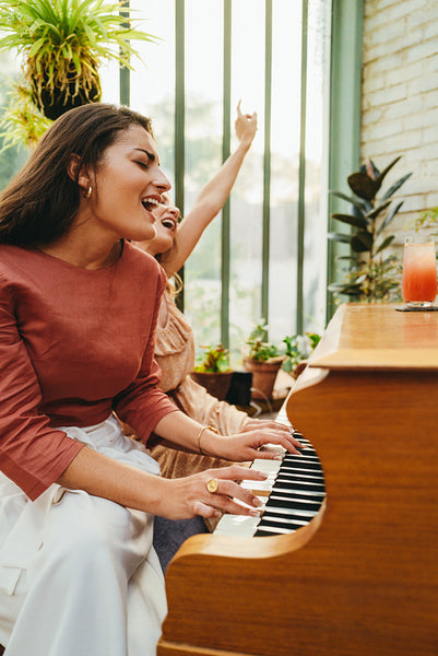 Joyful friends singing their favourite piano song together