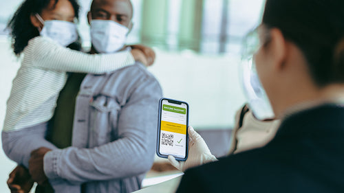 Airport staff with looking at vaccine certificate of travelers