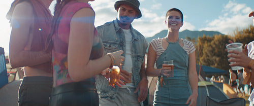 Joyful friends cheering and drinking beers at a festival