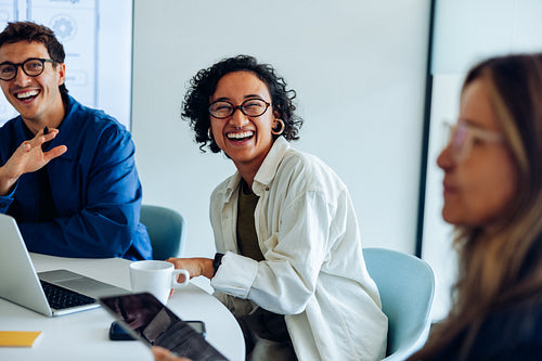 Co-workers in a lively team meeting laugh together
