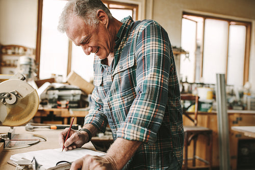 Carpenter preparing drawing for furniture parts