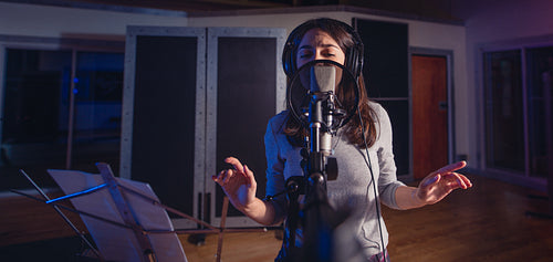 Female singer singing a song in recording studio