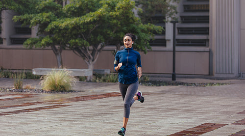 Woman running on street in the morning