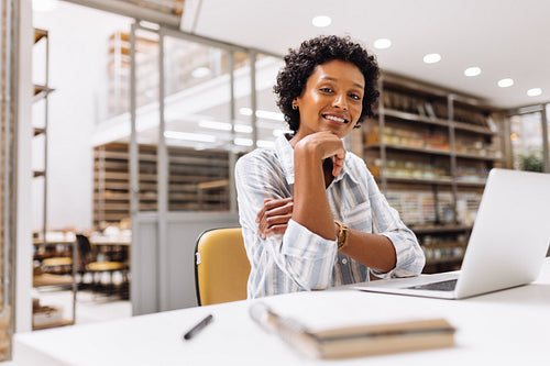 Ethnic entrepreneur smiling at the camera in a warehouse