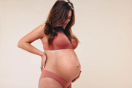 Expecting mother embracing body confidence in antenatal studio session