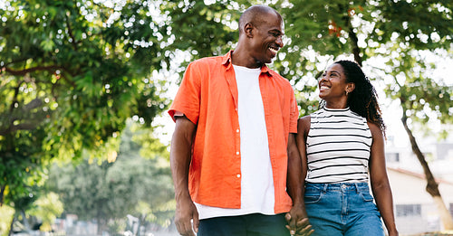 Happy black couple enjoying a fun walk in sunny park