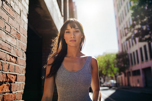 Beautiful young woman walking down the city street