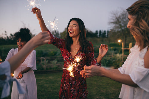 Multi-ethnic friends enjoying party with sparklers