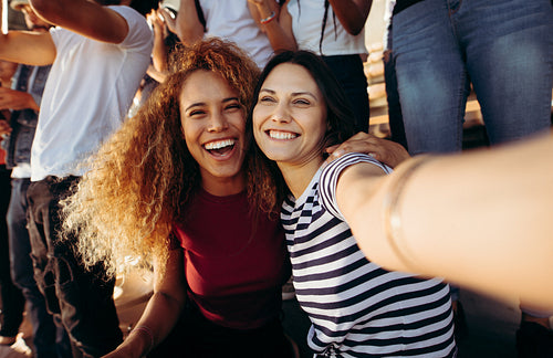 Female fans taking a selfie at a football match