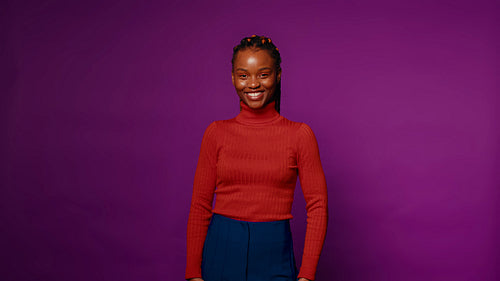 Young woman smiling and posing in studio with purple background
