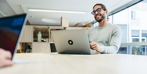 Happy young businessman working in a co-working office