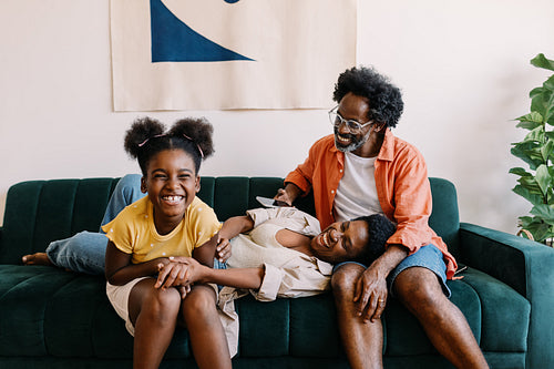 Daughter laughing and having fun while relaxing with her parents at home