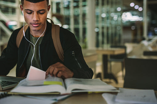 Male student studying in university library