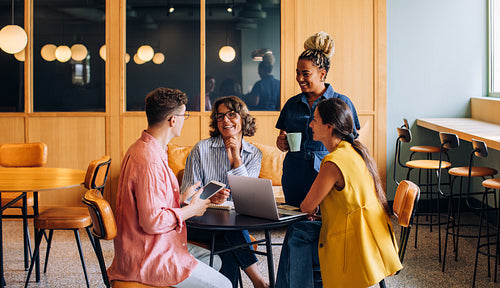 Diverse group of colleagues having a casual discussion in a coworking office