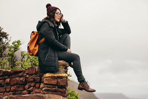 Woman traveler on mountain contemplating the view
