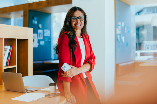 Confident female executive smiling in a contemporary office environment
