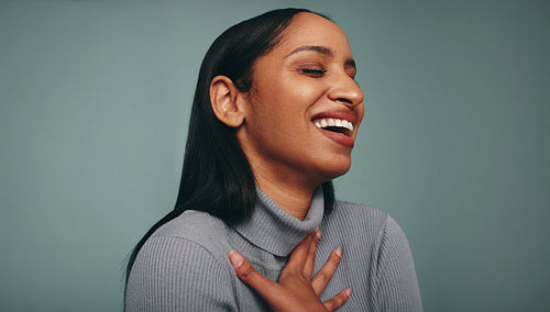 Young woman laughing cheerfully in a studio